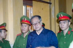 Dẫn giải bị cáo Phạm Công Danh ra xét xử tại phiên tòa 8/1. (Ảnh: Hoàng Hải/TTXVN)