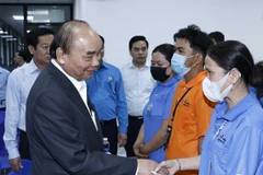 Chủ tịch nước Nguyễn Xuân Phúc động viên các công nhân, người lao động có hoàn cảnh khó khăn. (Ảnh: Thống Nhất/TTXVN)