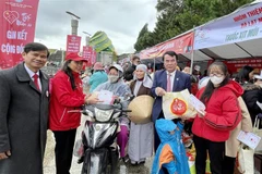 Phó chủ tịch UBND tỉnh Lâm Đồng Phạm S tặng quà cho người có hoàn cảnh khó khăn trong Hội chợ Tết nhân ái Xuân Quý Mão 2023. (Ảnh: Nguyễn Dũng/TTXVN)