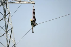 Kỹ thuật viên sửa chữa đường dây điện cao thế tại Karachi, Pakistan. (Ảnh: AFP/ TTXVN)