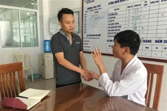 Bệnh nhân Đặng Ngọc Vạn (áo đen) đã được xuất viện sau gần 10 ngày điều trị tích cực. (Ảnh: TTXVN phát)