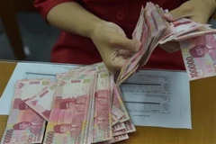 Nhân viên phòng giao dịch hối đoái kiểm tiền giấy rupiah tại thủ đô Jakarta, Indonesia. (Nguồn: AFP/TTXVN)