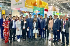 Đại sứ Việt Nam tại Đức Nguyễn Minh Vũ và Tham tán Thương mại Bùi Vương Anh chụp ảnh lưu niệm cùng đại diện các doanh nghiệp Việt Nam tham dự Anuga 2019. (Ảnh: Phạm Thắng/TTXVN)