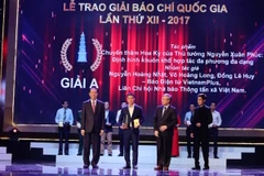 Nhà báo Nguyễn Hoàng Nhật đại diện nhóm tác giả thuộc báo điện tử VietnamPlus nhận giải A. (Ảnh: Minh Sơn/Vietnam+)