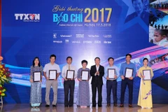 Tổng Giám đốc Thông tấn xã Việt Nam, Nguyễn Đức Lợi trao giải A cho các tác giả. (Ảnh: Minh Sơn/Vietnam+)