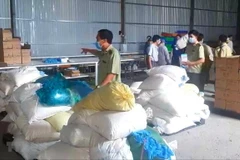 Kho chứa hàng găng tay y tế không đảm bảm chất lượng bị cơ quan chức năng phát hiện. (Ảnh: Huyền Trang/TTXVN)