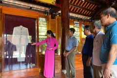 Du khách tham quan và nghe thuyết minh về những kỷ vật về Bác Hồ tại Nhà trưng bày bổ sung tại Khu di tích quốc gia đặc biệt Kim Liên. (Ảnh: Bích Huệ/ TTXVN)