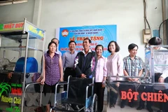 Ban vận động vì người nghèo quận 11 trao tặng phương tiện sinh kế cho hộ nghèo, hộ cận nghèo tại địa phương. (Ảnh: Đinh Hằng/TTXVN)