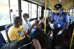 Cảnh sát nhắc nhở người dân các biện pháp phòng lây nhiễm COVID-19 tại Lagos, Nigeria. (Ảnh minh họa: AFP/TTXVN)