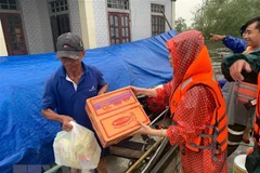 Hỗ trợ lương thực cho người dân vùng lũ. (Ảnh: TTXVN phát)