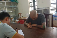 Đối tượng Phạm Hồng Giang tại cơ quan công an. (Nguồn: TTXVN)