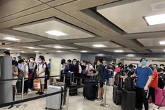 Công dân Việt Nam làm thủ tục trước khi lên máy bay. (Nguồn: TTXVN)