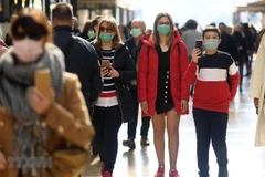 Người dân đeo khẩu trang để phòng tránh lây nhiễm COVID-19 tại Milan, Italy, ngày 24/2/2020. (Ảnh: THX/TTXVN)