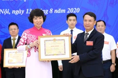 Tổng Giám đốc TTXVN Nguyễn Đức Lợi trao Bằng khen tặng Phó Tổng giám đốc TTXVN Vũ Việt Trang. (Ảnh: Thành Đạt/TTXVN)