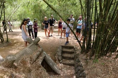 Du khách tham quan các hầm tránh bom được nối với hệ thống giao thông hào chằng chịt khắp làng hầm Vĩnh Linh, Quảng Trị.(Ảnh: Nhật Anh/TTXVN)