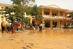 Giáo viên, phụ huynh học sinh Trường mầm non Võ Ninh, huyện Quảng Ninh, Quảng Bình dọn dẹp vệ sinh lại trường lớp ngay khi nước lũ rút. (Ảnh: Văn Tý/TTXVN)