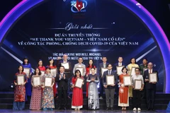 Chủ tịch Quốc hội Nguyễn Thị Kim Ngân và Trưởng Ban Tuyên giáo Trung ương Võ Văn Thưởng trao giải Nhất cho các tác giả, nhóm tác giả có tác phẩm đạt Giải thưởng toàn quốc về thông tin đối ngoại lần thứ VI, tối 28/7/2020. (Ảnh: Doãn Tấn/TTXVN)