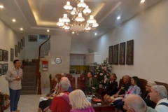 Giao lưu với khách nước ngoài khi đến xem múa rối nước (Nguồn: TTXVN)