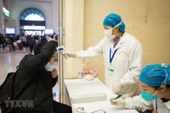 Kiểm tra thân nhiệt hành khách tại nhà ga đường sắt Hán Khẩu, thành phố Vũ Hán, tỉnh Hồ Bắc, Trung Quốc. (Ảnh: THX/TTXVN)