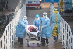 Nhân viên y tế chuyển bệnh nhân nhiễm virus corona chủng mới tới điều trị tại bệnh viện dã chiến Hỏa Thần Sơn ở Vũ Hán. (Ảnh: THX/TTXVN)