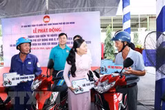 Bà Phan Kiều Thanh Hương, Phó Chủ tịch Ủy ban Mặt trận Tổ quốc Việt Nam Thành phố Hồ Chí Minh (giữa) trao tặng tượng trưng phương tiện sinh kế cho người nghèo. (Ảnh: Xuân Khu/TTXVN) 