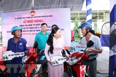 Bà Phan Kiều Thanh Hương, Phó Chủ tịch Ủy ban Mặt trận Tổ quốc Việt Nam Thành phố Hồ Chí Minh (giữa) trao tặng tượng trưng phương tiện sinh kế cho người nghèo. (Ảnh: Xuân Khu/TTXVN) 