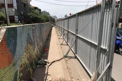 Những bức tranh gốm bị rào chắn chuẩn bị cho việc phá dỡ. (Ảnh: Lê Hồng/TTXVN) 