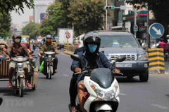 Người dân đeo khẩu trang để phòng tránh lây nhiễm COVID-19 tại Phnom Penh, Campuchia. (Ảnh: THX/TTXVN)