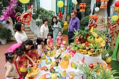 Cán bộ Đại sứ quán Pháp khám phá mâm cỗ Trung Thu truyền thống cùng cô và trò Trường Mầm non A (quận Hoàn Kiếm, Hà Nội). (Ảnh: Thanh Tùng/TTXVN)