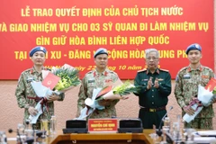 Thượng tướng Nguyễn Chí Vịnh, Thứ trưởng Bộ Quốc phòng trao Quyết định của Chủ tịch nước cho 3 sỹ quan thực hiện nhiệm vụ Gìn giữ hòa bình Liên hợp quốc tại Phái bộ Nam Sudan và Cộng hòa Trung Phi. (Ảnh: Dương Giang/TTXVN)