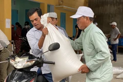 Người dân xã Phước Nam, huyện Thuận Nam nhận gạo hỗ trợ cứu đói do tác động của hạn hán. (Ảnh: Công Thử/TTXVN)