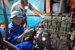 Cán bộ kỹ thuật Âu tàu đảo Sinh Tồn giúp ngư dân sửa chữa máy phát điện của tàu cá QNg 90431 TS. Ảnh: TTXVN phát