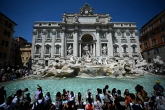 Khách du lịch giải nhiệt tại đài phun nước Barcaccia trong thời tiết nắng nóng gay gắt tại Rome, Italy, ngày 21/8/2023. (Ảnh: AFP/TTXVN)