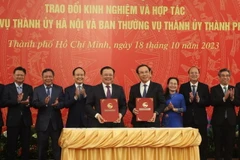 Ông Đinh Tiến Dũng, Bí thư Thành ủy Hà Nội và ông Nguyễn Văn Nên, Bí thư Thành ủy Thành phố Hồ Chí Minh ký kết biên bản hợp tác giữa hai thành phố. (Ảnh: Anh Tuấn/TTXVN)