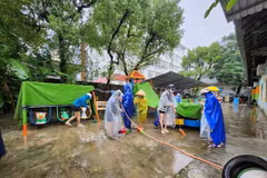 Các giáo viên khẩn trương dọn dẹp bùn non trên sân trường. (Ảnh: Mai Trang/TTXVN)