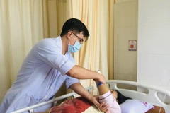 Bác sỹ thăm khám cho bệnh nhân sau can thiệp. (Ảnh: TTXVN phát)