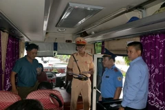 Các lực lượng chức năng tỉnh Quảng Ninh phối hợp kiểm tra kiểm soát xe ôtô vận tải hành khách. (Ảnh: Thanh Vân/TTXVN)