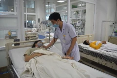 Bác sỹ Bệnh viện Đa khoa vùng Tây Nguyên thăm khám cho bệnh nhân bị rắn cắn. (Ảnh: Nguyên Dung/TTXVN)