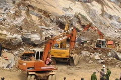 Lực lượng cơ giới cứu hộ tại hiện trường. (Ảnh: Nguyễn Văn Nhật/TTXVN)