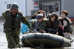 Binh sĩ Nhật Bản giúp sơ tán người dân khỏi các khu vực ngập lụt sau trận động đất ở Miyagi ngày 13/3. (Ảnh: AFP/TTXVN)