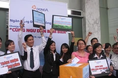 Nhân viên DongA Bank và khách hàng cùng quyên góp ủng hộ ngư dân bám biển. (Ảnh: Hà Huy Hiệp/Vietnam+)