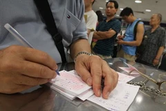 Một người đang thử vận may trong khi phía sau là hàng dài xếp đợi đến lượt. (Ảnh: Internet)