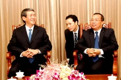 Bí thư Trung ương Đảng, Trưởng Ban Tuyên huấn Trung ương Lào, Chueang Sombounkhan và ông Đinh Thế Huynh. (Ảnh: Hoàng Chương/TTXVN)