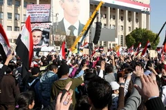 Nhiều người Syria tuần hành bày tỏ sự ủng hộ đối với Tổng thống Bashar al-Assad tại thủ đô Damascus ngày 19/12. (Ảnh: AFP/TTXVN)