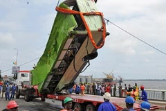 Trục vớt chiếc xe buýt gặp nạn ngày 5/8. (Ảnh: THX/TTXVN)