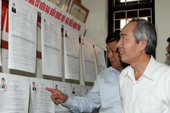 Phó Chủ tịch Hội đồng bầu cử Trung ương kiểm tra danh sách cử tri tại nơi niêm yết - phường Ninh Xá, thành phố Bắc Ninh. (Ảnh: Nguyễn Dân/TTXVN)