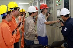 Các kỹ sư, công nhân ấn nút khởi động chạy không tải tổ máy số 2. (Ảnh: Điêu Chính Tới/TTXVN)