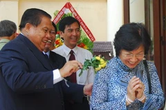 Tổng Lãnh sự Thetlakhone Đouangsonthi tắm nước Phật theo nghi thức Tết của Lào cho đại biểu. (Ảnh: Hoàng Hải/TTXVN)