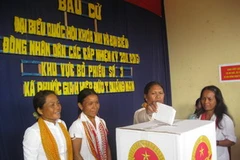 Cử tri người dân tộc Cadoong nhận phiếu bầu và tham gia bầu cử tại Phước Gia. (Ảnh: Nguyễn Sơn/Vietnam+)