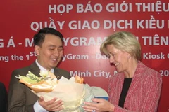 Đại diện Ngân hàng Đông Á tặng hoa bà Pamela H. Pastley tại lễ khai trương. (Ảnh: Hà Huy Hiệp/Vietnam+)